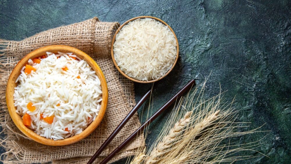 top-view-delicious-boiled-rice-with-raw-rice-inside-little-plate-dark-desk-scaled