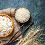 top-view-delicious-boiled-rice-with-raw-rice-inside-little-plate-dark-desk-scaled